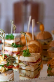 assorted canapes on a glass tray on a buffet table.