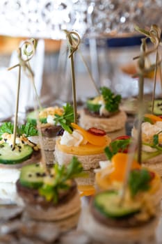 assorted canapes on a glass tray on a buffet table.