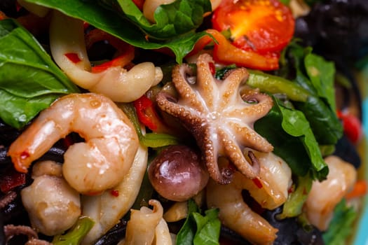 seafood salad in a blue plate in a restaurant. Shrimp, octopus squid close-up.