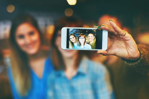 These are the memories well hold for life. three young friends taking a selfie together in a cafe