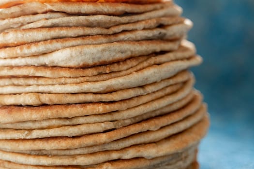 Flatbread lavash, chapati, naan, heap of tortilla on a blue background Homemade flatbread stacked