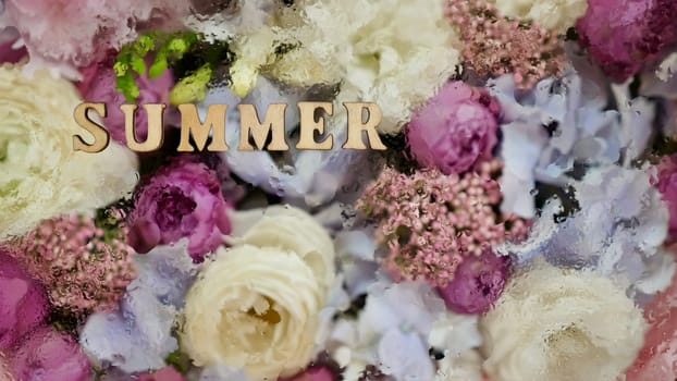 floral flowers background with the inscription summer with water droplets. wooden letters, close-up, top view, abstract