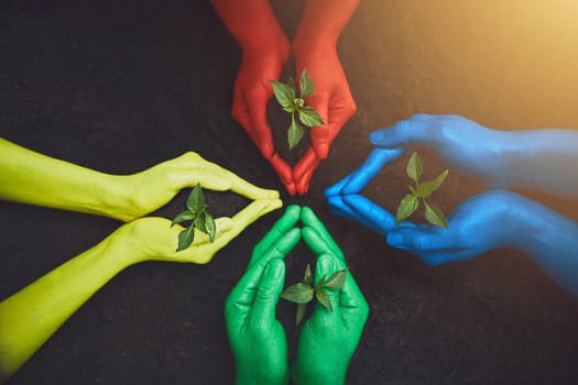 Helping hands make a difference. unrecognizable people holding budding plants in their multi colored hands