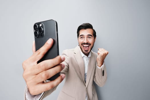 mobile man happy connection cell smile studio confident application suit person portrait call beige phone white phone holding internet hold smartphone business