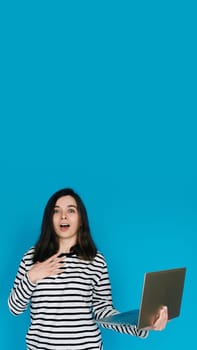 Excited Woman in Striped Sweater Writing Email on Laptop - Modern Technology and Communication Concept. Empty Space for Text - Isolated on Blue Background - Perfect for Business and Technology Themes