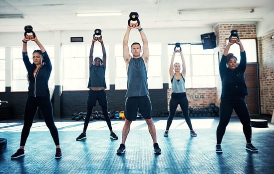 Give group dynamics a try. a fitness group using kettle-bells in their session at the gym