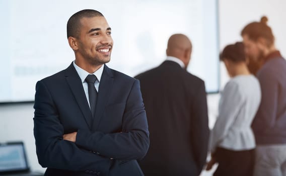 Envisioning the future. a young businessman in the office with his colleagues in the background