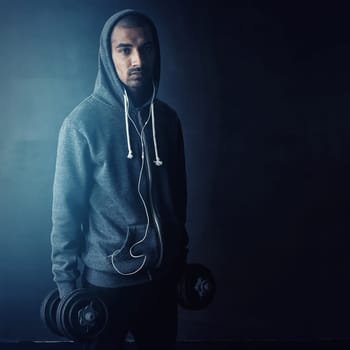 Weight. Im lifting. Studio portrait of a young man working out against a dark background