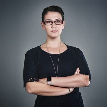 Her competitive drive compels her to be the best. Studio portrait of a confident young businesswoman posing against a grey background