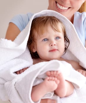 Mom, hug and baby with bath for care or clean kid in a closeup at home with love for family life. Infant, towel and mother to hold with caring in arm for bond or cleaning or wellness of child