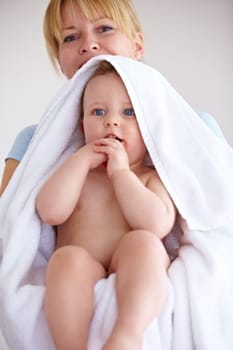 Baby, towel and portrait with care for mother with comfort or love in a closeup or family home. Mom, hug and holding an infant for bath with cleaning or affection at house for hygiene with happy kid
