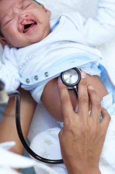 Stethoscope, cleft palate and baby in medical exam and crying in a newborn hospital or clinic for healthcare. Doctor, pediatrician and infant child get cardiology test or check for care and health.