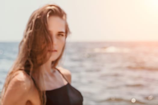 Woman travel sea. Young Happy woman in a long red dress posing on a beach near the sea on background of volcanic rocks, like in Iceland, sharing travel adventure journey