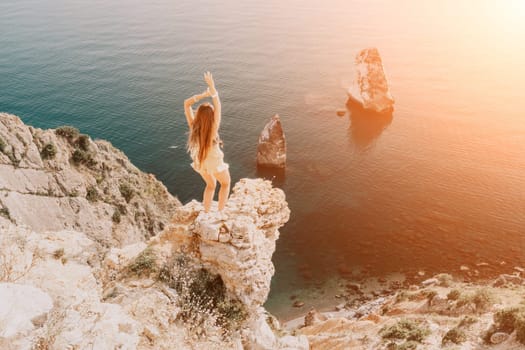 Woman travel sea. Happy tourist taking picture outdoors for memories. Woman traveler looks at the edge of the cliff on the sea bay of mountains, sharing travel adventure journey.