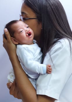 Healthcare, cleft palate and a pediatrician with a baby in the hospital for insurance, care or treatment. Medical, kids and a doctor woman holding a newborn with a disability in a health clinic.