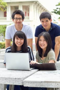 Smile, portrait and students with a laptop for education, studying and college research. Happy, Asian and men and women with a computer and notes for university work, learning and a group project.