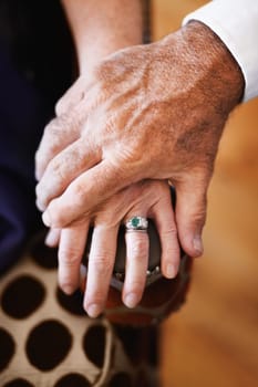 Closeup, holding hands and senior couple with support, empathy and comfort with care, solidarity and loving together. Zoom, fingers and old woman with elderly man, romance or love with trust or grief.