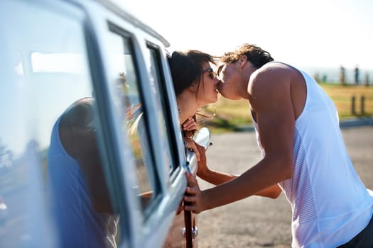 Kiss, love and a couple on a road trip in a van for a holiday, adventure or a drive. Care, romantic and a man and woman kissing in nature with transportation for a honeymoon vacation or date.