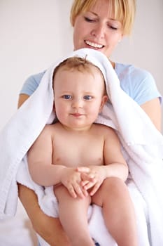 Baby, mom and hug for bath with care in a closeup for clean kid at home with love and caring. Towel, mother and infant with portrait to hold or hugs for care and love with kid in family home