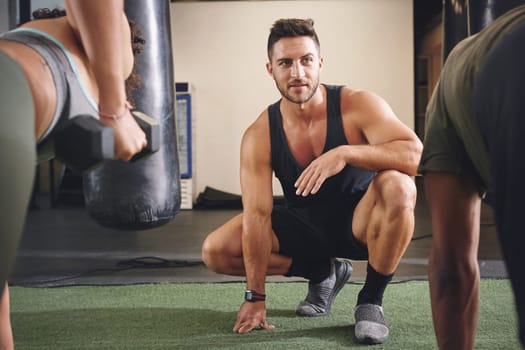 Ill help them reach their fitness goals. two people working out with a fitness instructor at the gym