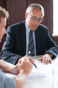 Planning, businessmen with paperwork and in a business meeting together in a boardroom. Finance support or consulting, collaboration or teamwork and colleagues discussing in a modern workplace office.