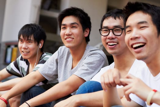 Happy, relax and men together on the weekend for happiness, friendship and bonding. Smile, teenager and Asian friends laughing, talking and having fun while watching a soccer game or competition.