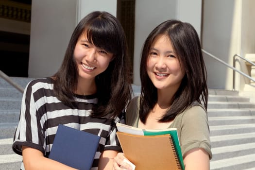 College, happy and portrait of girl friends with scholarship standing outdoor on campus for education. Knowledge, smile and Japanese female university students by a school building in the city