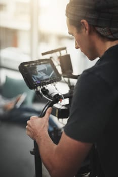 Keep rolling. Behind the scenes shot of a camera operator shooting a scene with a state of the art camera inside of a studio during the day