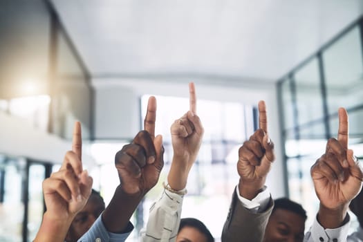 We need some answers. Closeup shot of a group of businesspeople raising their hands in an office