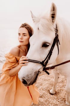 A woman in a dress stands next to a white horse on a beach, with the blue sky and sea in the background