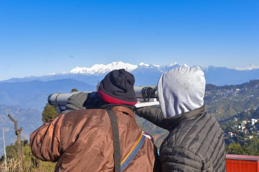 Tourist people looking through binoculars. Rear view.