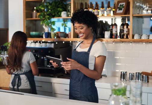 Happy woman, tablet and waitress in management at cafe for order, inventory or checking stock at restaurant. African female person, barista or manager on technology for small business at coffee shop.