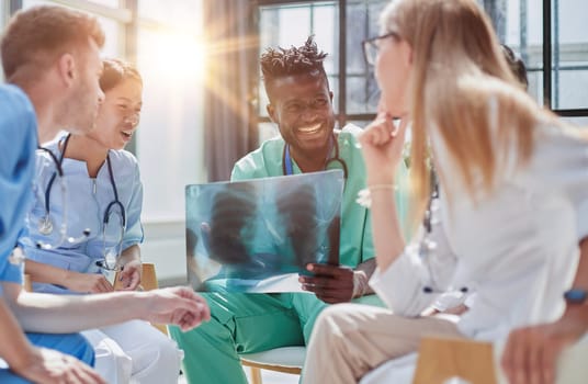Young group of oral surgeons looking at x-ray while preparing for surgery procedure.