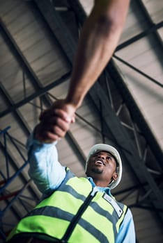 Black man, architect and handshake for construction, building or hiring in teamwork partnership on site. Low angle of African male engineer shaking hands in recruiting, architecture agreement or deal.