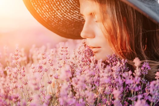 Close up portrait of young beautiful woman in a white dress and a hat is walking in the lavender field and smelling lavender bouquet.