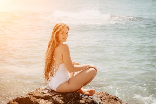 Woman travel sea. Young Happy woman in a long red dress posing on a beach near the sea on background of volcanic rocks, like in Iceland, sharing travel adventure journey