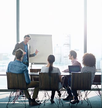 Meeting, education and whiteboard with a business man in the boardroom for training or coaching presentation. Workshop, management or leadership with a male employee teaching to his team in an office.