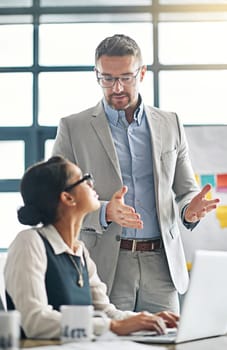 Let me explain. a businessman explaining something to a female colleague