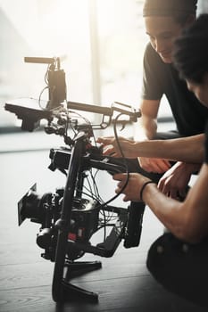 Pay attention to detail. Behind the scenes shot of two young camera operators shooting a scene with a state of the art camera inside of a studio during the day
