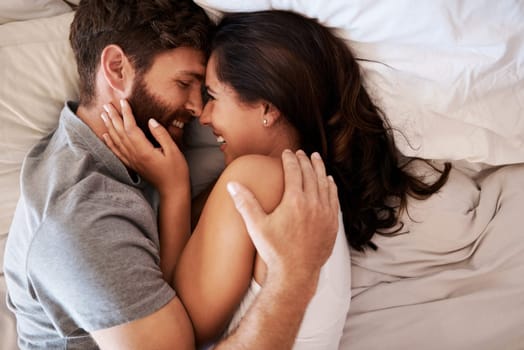 Morning, bedroom hug and happy couple laugh at funny joke, relationship humor or comedy on honeymoon vacation. Affection, marriage and top view of relax man, woman or bonding people laughing in bed.