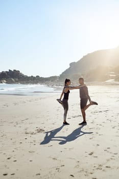 I know I can always lean on you for support. a sporty young couple stretching while exercising along the beach