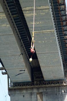 Varna, Bulgaria - August, 21, 2021: a man jumping from a road bridge with an elastic band