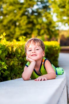 The child spends time in the park, he is very happy. Have fun and enjoy a summer day. Walking and recreation. Portrait of a happy child