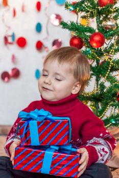 Portrait of a cute boy with a gift in his hands. Children's emotions. Christmas and new year. The concept of an advertising banner.