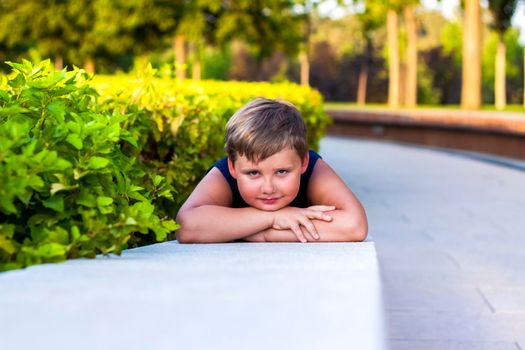 The child spends time in the park, he is very happy. Have fun and enjoy a summer day. Walking and recreation. Portrait of a happy child