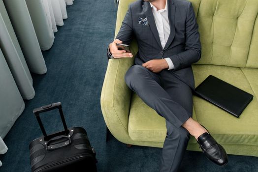 Young businessman working from a hotel room with his mobile phone