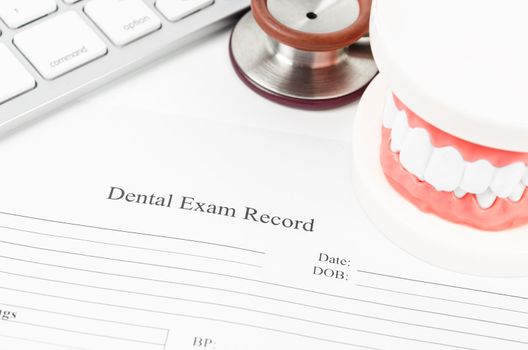 Dental exam record and model teeth with stethoscope medical on work table.