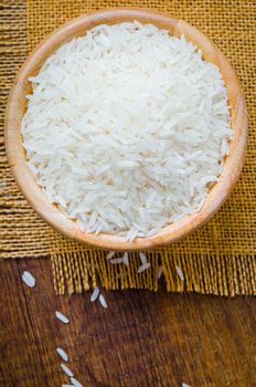 Organic Thai Jasmine rice grain in wooden bowl preparing for cooked.