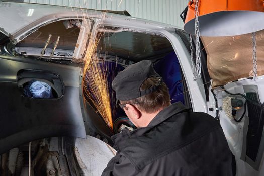 Cutting metal part with sparks in car service station