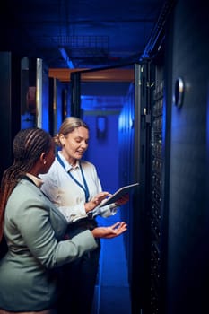 Sorting a new plan for repairs. two technicians using a digital tablet while working in a server room